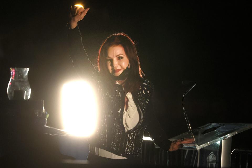 Priscilla Presley greets fans of her late husband Elvis as they attend the annual candlelight vigil outside his home at Graceland on Sunday, Aug. 15, 2021. The remembrance leads into the anniversary of his death on Aug. 16, 1977.