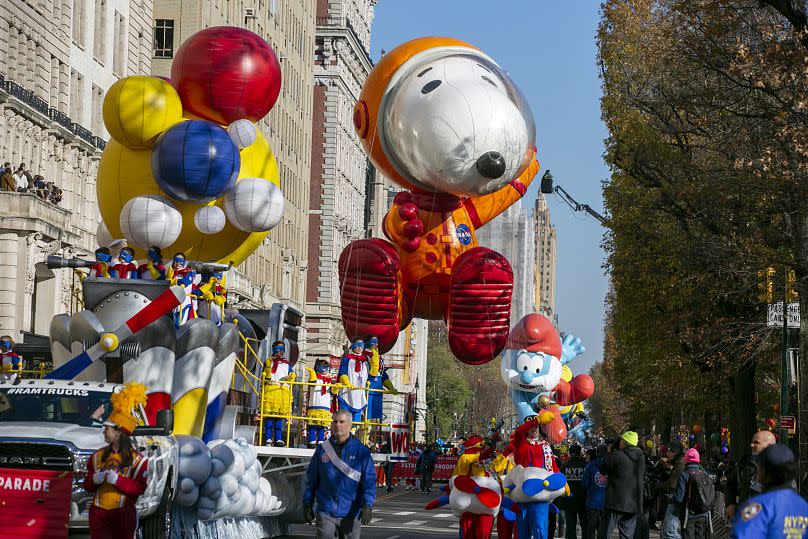 Comic strip characters Snoopy and Papa Smurf are seen as floats in the 2022 Thanksgiving Day parade in New York City.