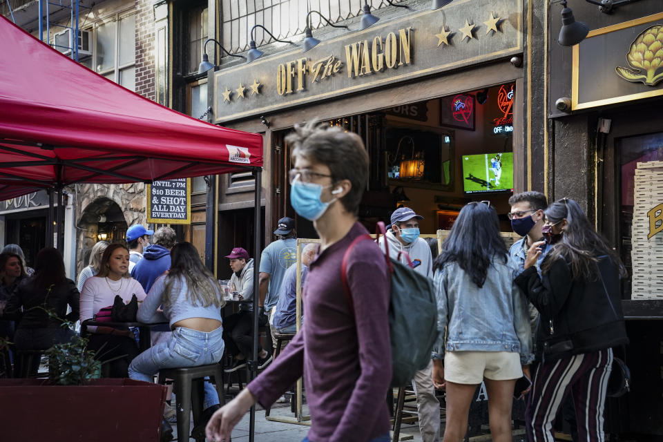 Diners sit outside restaurants offering outdoor service as part of continued COVID-19 economic impact mitigation efforts, Saturday, Oct. 3, 2020, in New York. (AP Photo/John Minchillo)