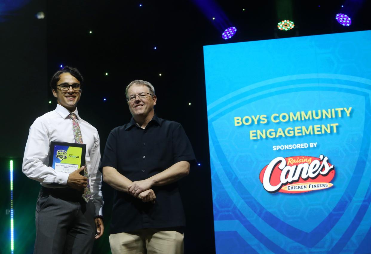 Angel Rivera-Martinez, a 2022 Ready graduate, receives his Raising Cane’s Community Engagement Award from ThisWeek sportswriter Jarrod Ulrey during the Central Ohio High School Sports Awards on June 15 at the Ohio Theatre.