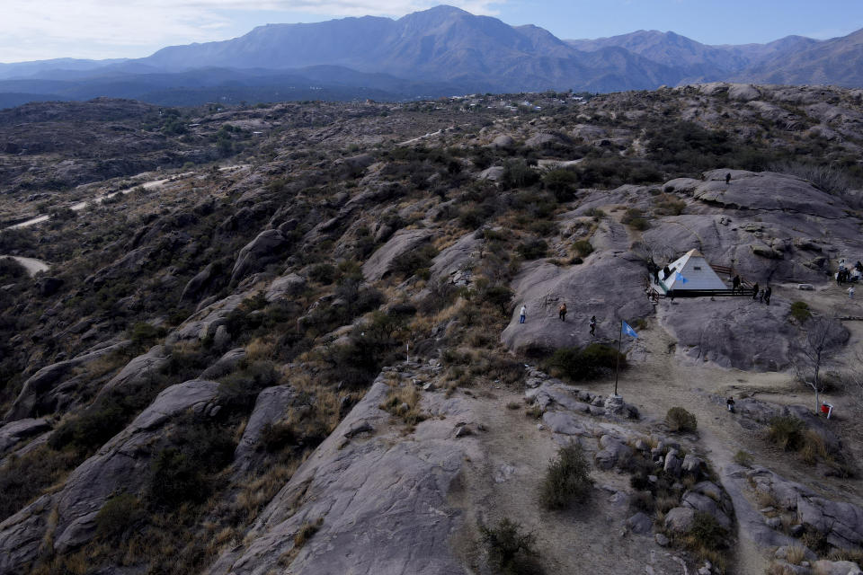 Un grupo de personas camina hacia una estructura con forma piramidal utilizada para meditar y ceremonias espirituales no religiosas, con la montaña Uritorco al fondo, en Capilla del Monte, Argentina, el 18 de julio de 2023. En la patria del papa Francisco, Argentina, algunos católicos han renunciado a la fe y se han sumado a las crecientes filas de los no afiliados religiosamente. Conocidos como “nones” —que puede traducirse como “ninguna”, por “ninguna religión”— se identifican como ateos, agnósticos, espirituales pero no religiosos o, simplemente, nada en particular. (AP Foto/Natacha Pisarenko)