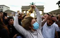 <p>A demonstrator cuts hair during a protest following the death of Mahsa Amini, in front of the Brandenburg Gate in Berlin, Germany, September 23, 2022. REUTERS/Christian Mang</p> 