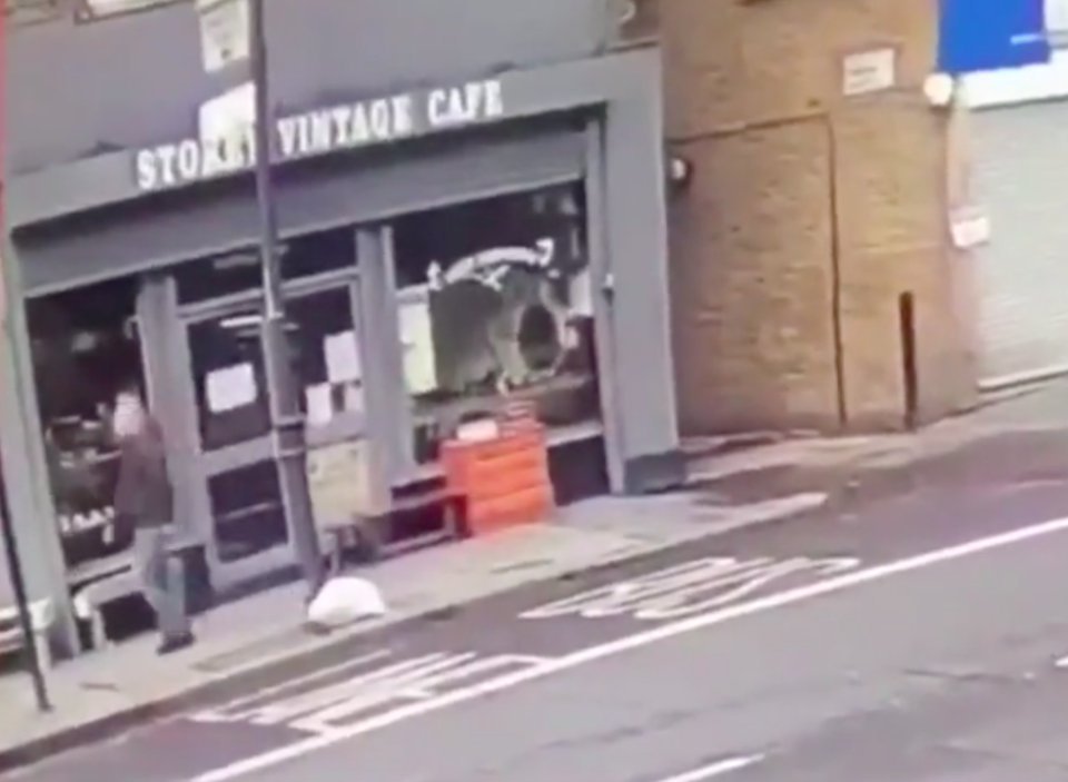 The man walks past the cafe just seconds before its roof collapses (Picture: Hackney Wick FC/Twitter)