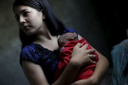 Ianka Mikaelle Barbosa, 18, poses for a photograph with Sophia, 18 days old, who is her second child and was born with microcephaly, at her house in Campina Grande, Brazil February 17, 2016. REUTERS/Ricardo Moraes