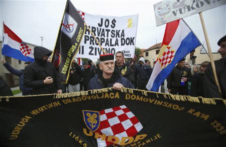 A man carries a flag during a ceremony to mark the 22th anniversary of Vukovar's fall, in downtown Vukovar November 18, 2013. REUTERS/Antonio Bronic