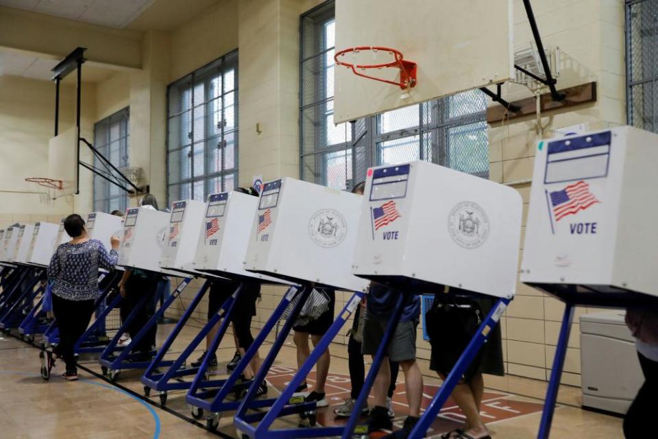 People stand in privacy booths as they fill ballots at PS 250 during the New York City primary mayoral election in Brooklyn.