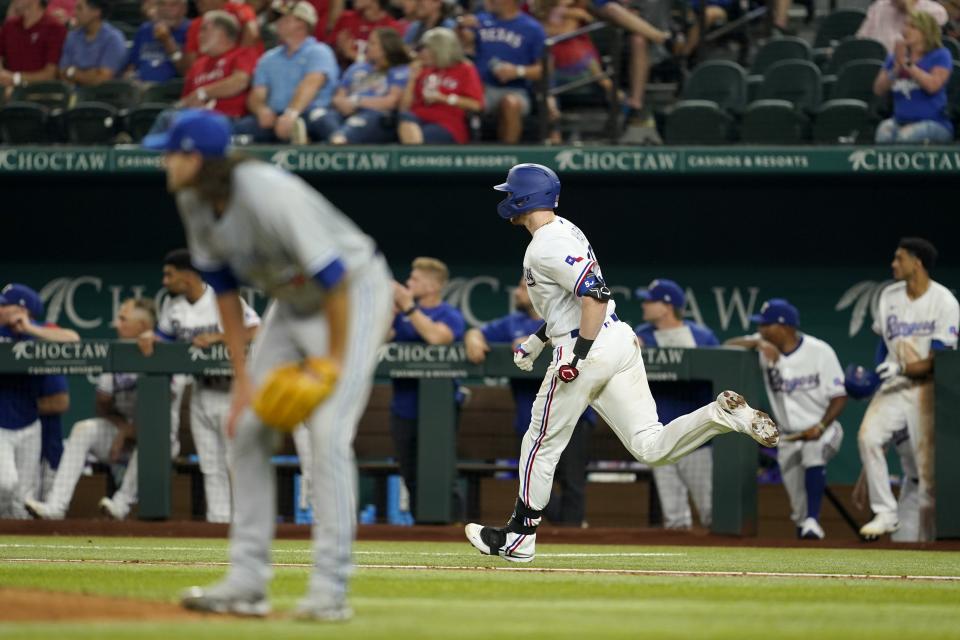 Texas Rangers' Sam Huff rounds the bases after hitting a two-run home run off Toronto Blue Jays starting pitcher Kevin Gausman, front left, in the sixth inning of baseball game in Arlington, Texas, Saturday, Sept. 10, 2022. (AP Photo/Tony Gutierrez)