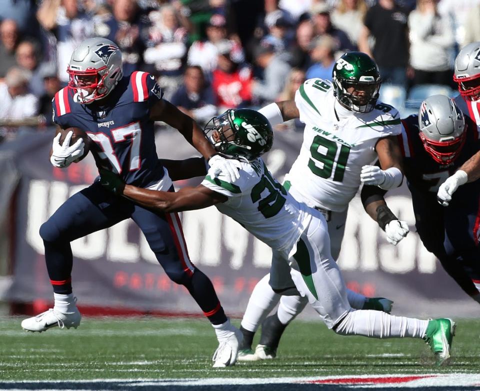 Patriots running back Damien Harris (47) finds running room in the first quarter as the Jets' Marcus Make tries to make the tackle.