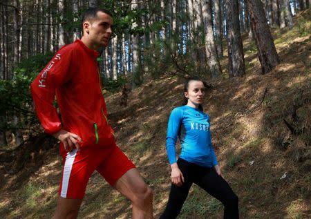 Kosovo's 800 metre runner Musa Hajdari and his team mate 400 metres runner Vijona Kryeziu exercise in the woods of the village Rogane in Kamenica, Kosovo, July 30, 2016. The runners train in the woods because there was no athletics stadium nearby. The Rio Games will be the first to host athletes competing under the flag of Kosovo. REUTERS/Hazir Reka