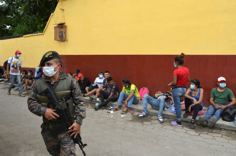 A Guatemalan soldier patrols to prevent a group of Honduran migrants who are trying to reach the U.S. , from moving towards the Guatemala and Mexico border, as they sit outside the migrant shelter, in Tecun Uman