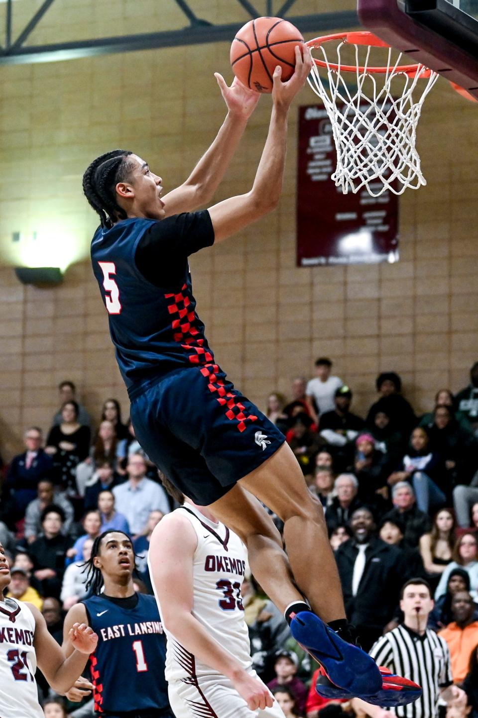 East Lansing's Cameron Hutson scores against Okemos during the second quarter on Thursday, Jan. 25, 2024, at Okemos High School.