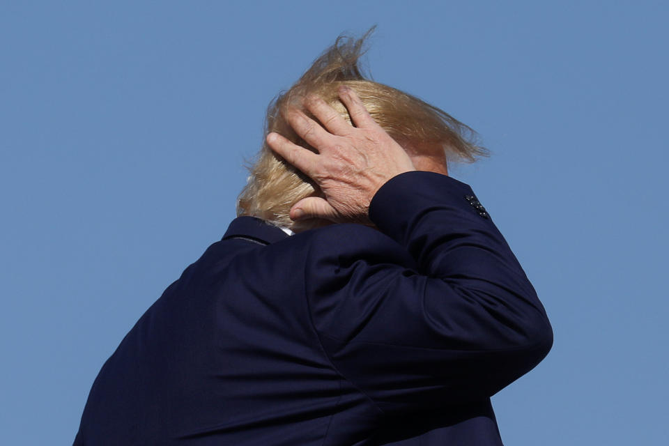 President Donald Trump holds on his hair as he boards Air Force One to depart Washington for travel to Pennsylvania from Joint Base Andrews, Maryland, U.S., October 23, 2019. REUTERS/Leah Millis