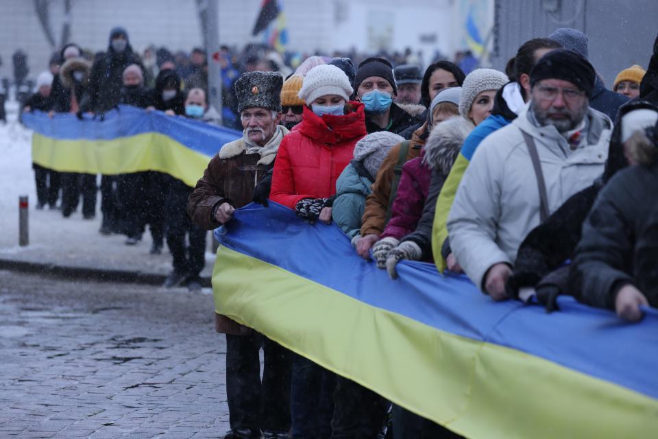 People rallying in patriotic support of Ukraine hold a 500 meter long ribbon in the colors of the Ukrainian flag on Unity Day on January 22, 2022 in Kyiv, Ukraine.