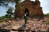 A photograper walks outside a collapsed pagoda after an earthquake in Bagan, Myanmar August 25, 2016. REUTERS/Soe Zeya Tun