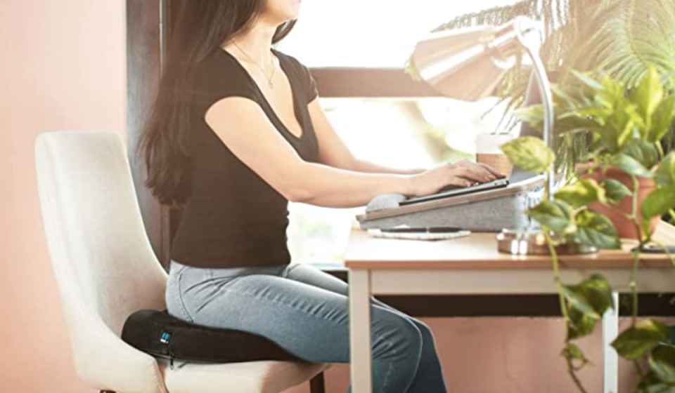 Woman sitting on a chair with a donut pillow seat cushion