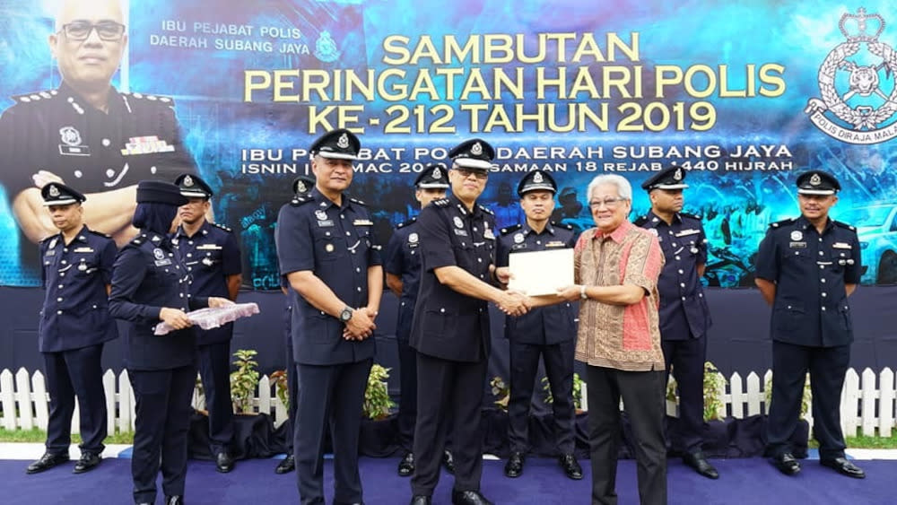 Penghulu (in batik shirt) receiving an appreciation certificate from former Subang Jaya OCPD for his efforts in community policing. — Picture courtesy of Teoh Teik Hoong