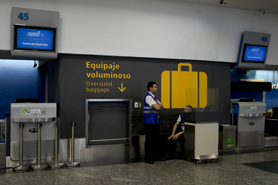 Workers talk in a baggage area at the Jorge Newbery airport in Buenos Aires, Argentina, Wednesday, Feb. 28, 2024. Airport and airline workers, as well as pilots, are staging a 24-hour strike for improved wages. (AP Photo/Natacha Pisarenko)