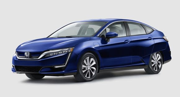 A blue Honda Clarity Electric, a midsize sedan.