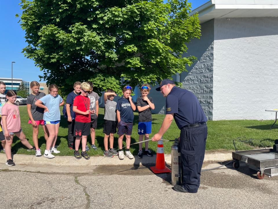 Marysville Fire Department firefighter Kyle Csiki demonstrating how to use a fire extinguisher to Marysville fourth graders on May 23, 2024.