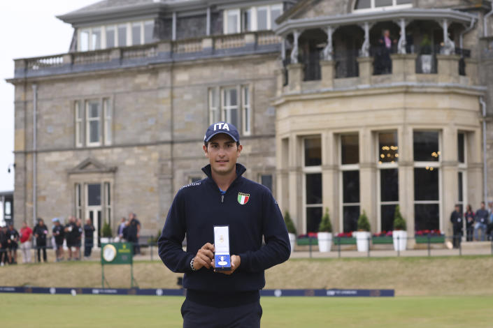 Leading amateur Italy's Filippo Celli holds the silver medal as he poses for photographers on the 18th green after winning the British Open golf Championship on the Old Course at St. Andrews, Scotland, Sunday July 17, 2022. (AP Photo/Peter Morrison)