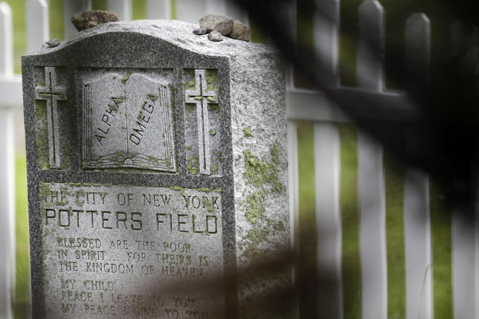 FILE - In this May 23, 2018, file photo, a stone proclaiming "The City of New York Potters Field" is displayed on Hart Island in New York. The island has served as New York City's potter's field for 150 years, where part of the graveyard along the island's shoreline is gradually washing away. (AP Photo/Seth Wenig, File)