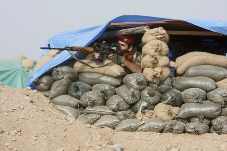 A Kurdish Peshmerga fighter takes up position with weapon at the frontline against the Islamic State, on the outskirts of Mosul. REUTERS/Azad Lashkari