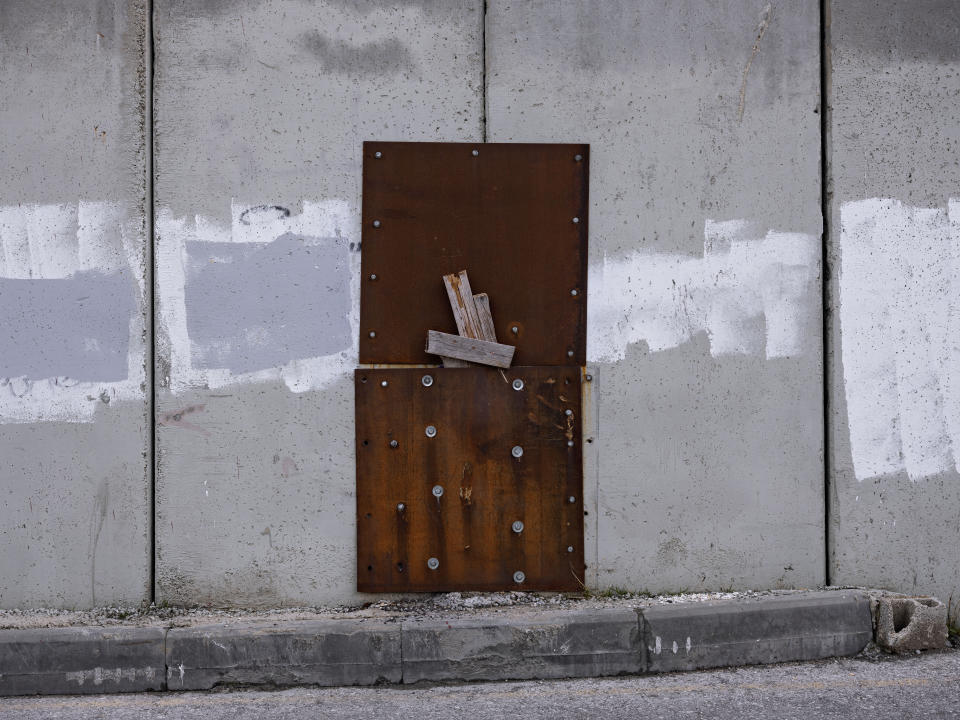 Metal sheets attached to a repaired a section of the Israeli separation barrier in the West Bank village of Abu Dis in the outskirts of Jerusalem, Monday, Jan. 31, 2022. Twenty years after Israel decided to built its controversial separation barrier amid a wave of Palestinian attacks, it remains in place, even as Israel encourages its own citizens to settle on both sides and admits tens of thousands of Palestinian laborers. (AP Photo/Oded Balilty)