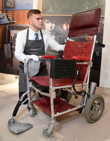 FILE PHOTO: Fine-art handler Tom Richardson poses with a motorised wheelchair belonging to British theoretical physicist Stephen Hawking ahead of an auction of items from Hawkings' personal estate at Christie's in London, Britain October 30, 2018. REUTERS/Toby Melville/File Photo