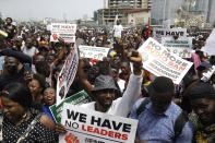 People hold banners as they demonstrate on the street to protest against police brutality in Lagos, Nigeria, Thursday Oct. 15, 2020. Protests against Nigeria's police continued to rock the country for the eighth straight day Thursday as demonstrators marched through the streets of major cities, blocking traffic and disrupting business. (AP Photo/Sunday Alamba)