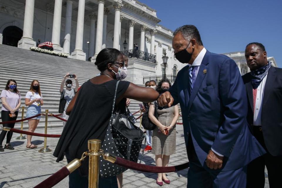 Tonya Jones, of New York City, left, bumps elbows with the Rev Jesse Jackson outside the Capitol on Tuesday.