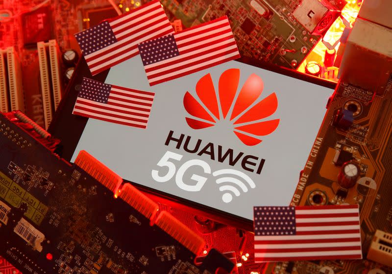 FILE PHOTO: The U.S. flag and a smartphone with the Huawei and 5G network logo are seen on a PC motherboard in this illustratio