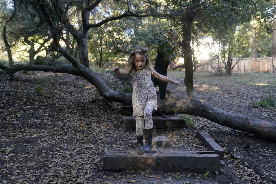 Hannah Levy, rear, follows with her daughter, Aylah, 6, at Codornices Park, a location Aylah attended as a Berkeley Forest School student, during an interview in Berkeley, Calif., Wednesday, Nov. 8, 2023. (AP Photo/Jeff Chiu)