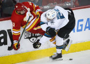 San Jose Sharks' Nicolas Meloche, right, checks Calgary Flames' Mikael Backlund during the first period of an NHL hockey game, Tuesday, Nov. 9, 2021 in Calgary, Alberta. (Jeff McIntosh/The Canadian Press via AP)