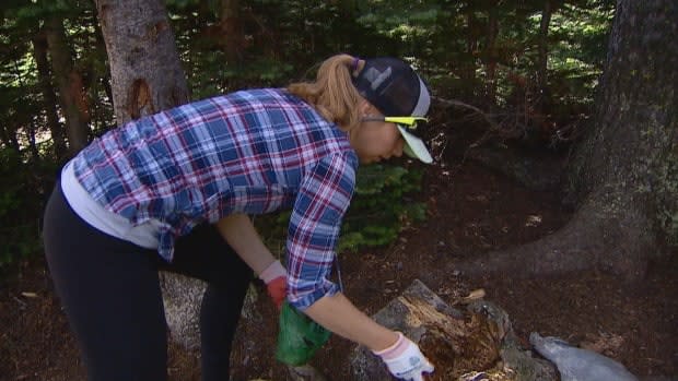 Trash on the trails inspired volunteer clean-up events in Alberta parks last year. Sarah Kuindersma is pictured picking up a poop bag on the trail in August 2020.