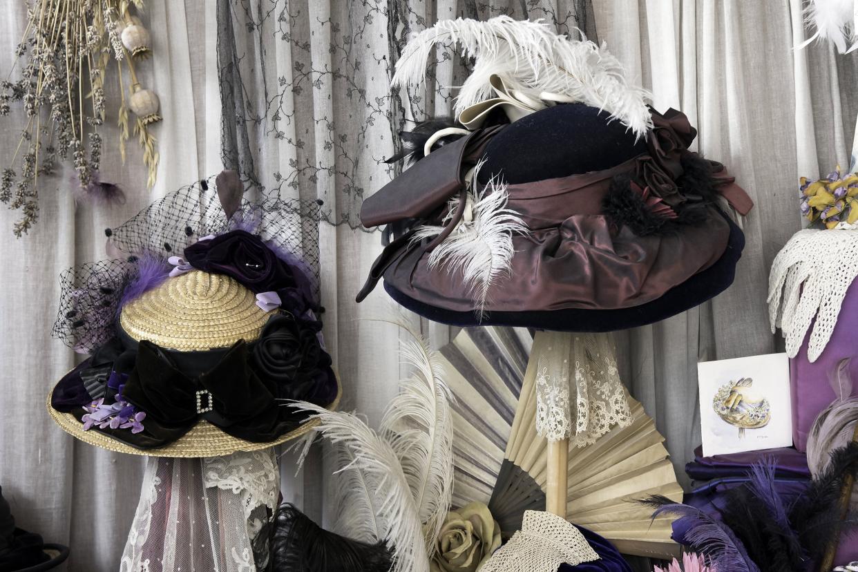 A Victorian hat shop window with feather hats on display