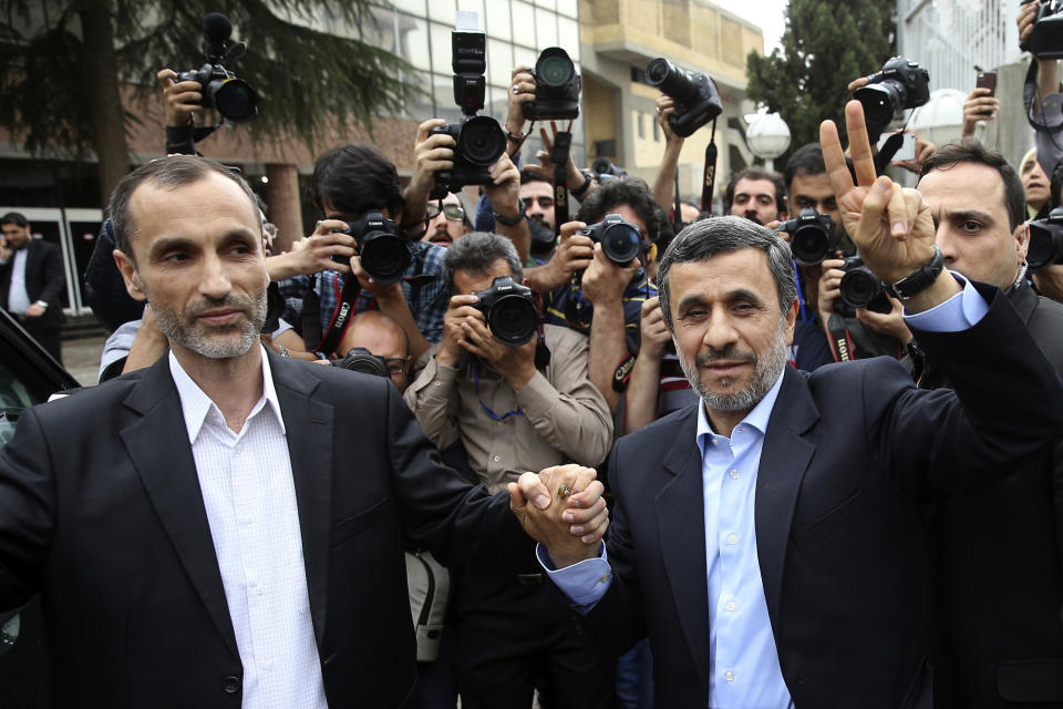 Former Iranian President Mahmoud Ahmadinejad, right, and his close ally Hamid Baghaei flash the victory sign as they arrive at the Interior Ministry to register their candidacy for the upcoming presidential elections, in Tehran, Iran, Wednesday, April 12, 2017. Ahmadinejad on Wednesday unexpectedly filed to run in the country's May presidential election, contradicting a recommendation from the supreme leader to stay out of the race. (AP Photo/Ebrahim Noroozi)