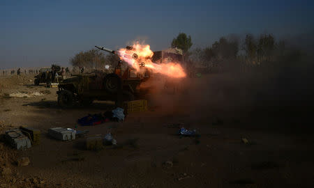 Popular Mobilization Forces (PMF) launch a rocket during clashes with Islamic State militants on the outskirts of the town of Hammam Al-Alil in south of Mosul, Iraq October 30, 2016. REUTERS/Stringer