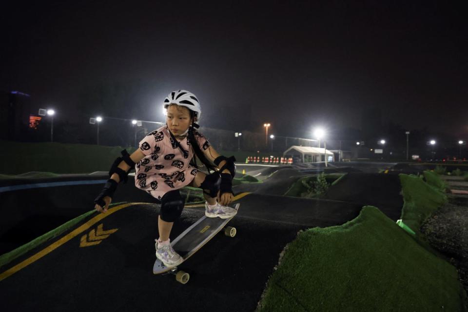 Zhang Qianqian, 9, a junior member of Beijing Girls Surfskating Community, rides a skateboard at a pump track in Beijing (Reuters)