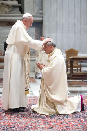 Pope Francis puts his hands on the head of Archbishop Konrad Krajewski during a ceremony in Saint Peter's Basilica at the Vatican September 17, 2013. Picture taken September 17, 2013. Vatican Media/Handout via REUTERS