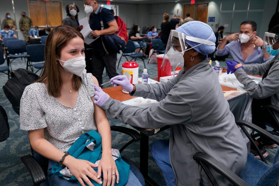 Natalia Dubom, of Honduras, gets the Johnson & Johnson COVID-19 vaccine on Friday at Miami International Airport. The vaccine will be offered to all arriving passengers through Sunday as part of a Florida Emergency Management Agency program.