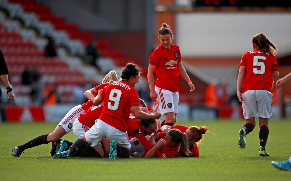 Manchester United Women pile on Katie Zelem after she scores the opener in the derby - PA