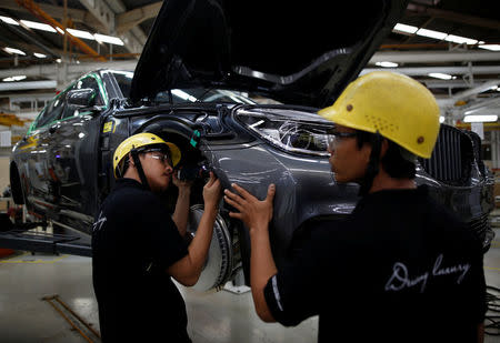 Workers install a part on a locally assembled new BMW 7 Series on the production line at a Gaya Motor assembly plant in Jakarta, Indonesia November 30, 2016. REUTERS/Darren Whiteside