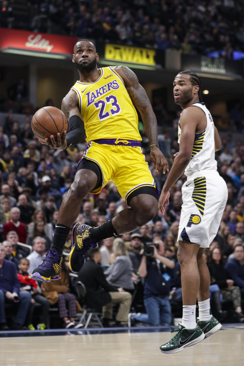 Los Angeles Lakers forward LeBron James (23) shoots behind Indiana Pacers forward T.J. Warren (1) during the first half of an NBA basketball game in Indianapolis, Tuesday, Dec. 17, 2019. (AP Photo/Michael Conroy)