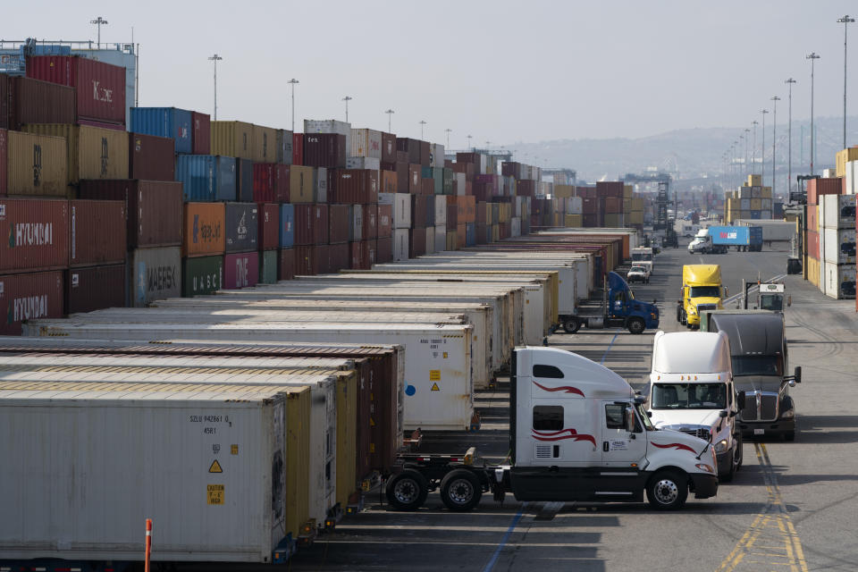 Dozens of trucks lines up next to shipping containers at the port. (Source: AP)