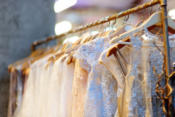 Close-up of wedding dresses on vintage clothing rack.