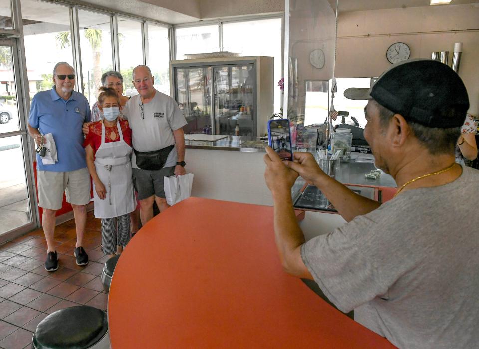 Donut Circus owners Ernie Sao (right) and his wife Sophia Sao (center left) photograph their customers (from left) Len Chamberlin, Ginger and Joe Rodriguez, all of Fort Pierce, on Tuesday, April 23, 2024, in Fort Pierce. The business announced it is closing. Their last day open is Wednesday, April 24, 2024.