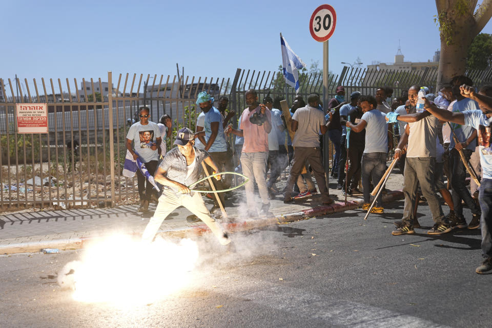 A stun grenade thrown by Israeli police explodes next to Eritrean protesters during a protest against an event organized by the Eritrea Embassy, in Tel Aviv, Israel, Saturday, Sept. 2, 2023. Hundreds of Eritreans, those seeking asylum in Israel after fleeing repression in Eritrea as well as those supporting the heavily sanctioned regime, clashed together and fought with police, breaking cars and shop windows. The Israeli police said 27 officers were injured in the clashes, and at least three protesters were shot when police opened fire with live rounds when they felt "real danger to their lives." (AP Photo/Ohad Zwigenberg)
