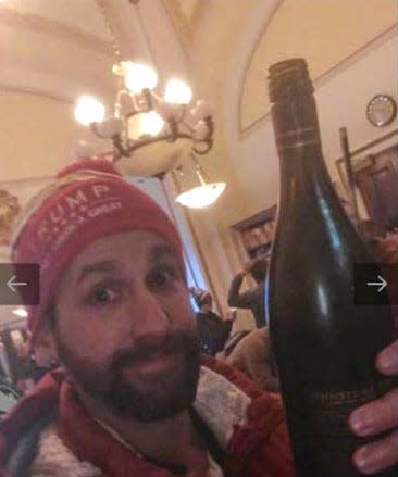 Jason Riddle of New Hampshire with a bottle of wine he found in the Senate Parliamentarian's office. Riddle was arrested on charges related to his participation in the Jan. 6 Capitol riot.
