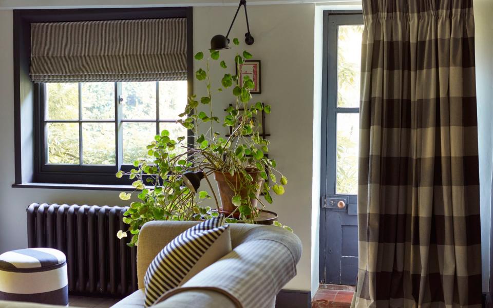 A curtain rail and thick curtain in front a door inside a country cottage