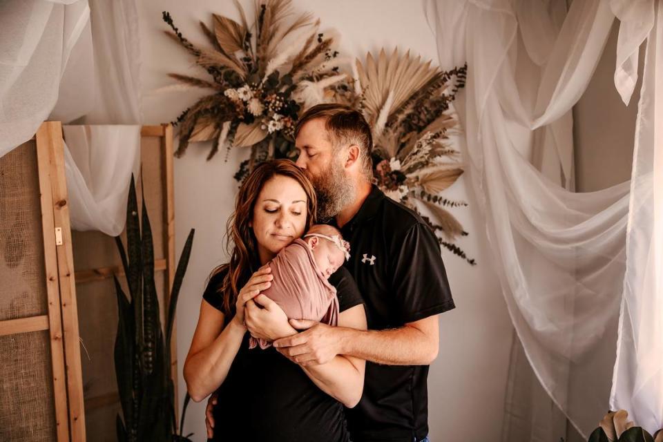 Kayla Pieshcke and Paul Warner pose with their newborn child. The Topeka couple is hoping their foster child’s day care will be able to open an infant room by the time the baby needs care.